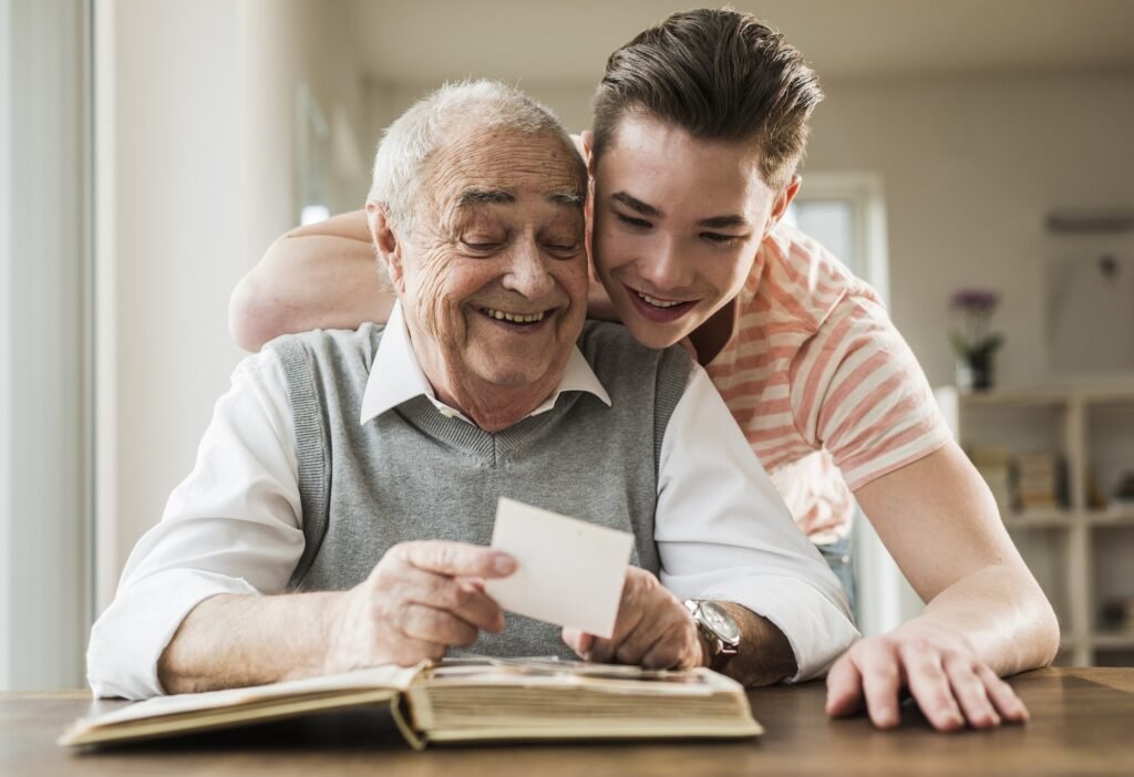Grandfather and grandson watching old photographies together